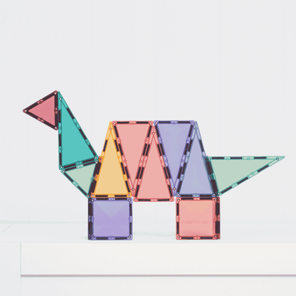 Colorful gmagnetic tiles arranged to form a dinosaur on a white background