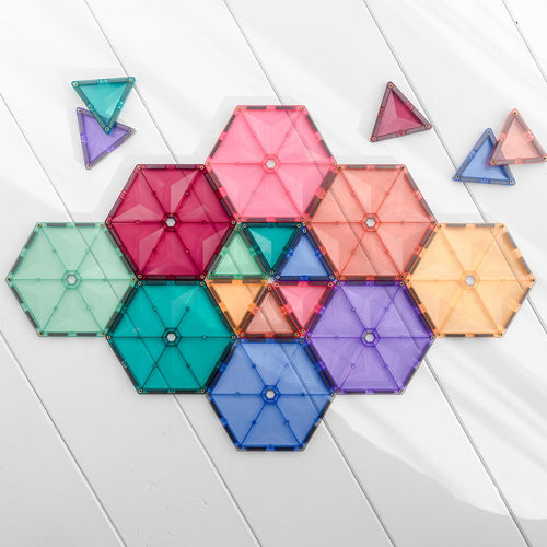 Colorful geometric magnetic building blocks on a light wooden surface